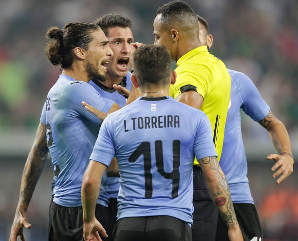 HOUSTON, TX - SEPTEMBER 07: Martin Caceres #22 of Uruguay argues with referee Ismael Elfath after a penaltyb kick was given to Mexico in the first ...