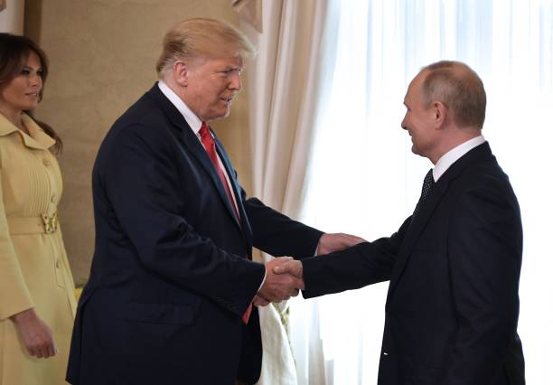 US President Donald Trump (C) shakes hands with Russia's President Vladimir Putin next to US First Lady Melania Trump (L) ahead a meeting in Helsinki, on July 16, 2018. - The US and Russian leaders opened an historic summit in Helsinki, with Donald Trump promising an 'extraordinary relationship' and Vladimir Putin saying it was high time to thrash out disputes around the world. (Photo by Alexey NIKOLSKY / Sputnik / AFP)