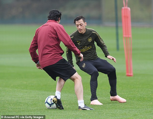 Unai Emery tries the shoulder drop on Mesut Özil / Arsenal FC via Getty Images