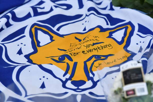 A flag showing the Leicester City Football Club's Fox logo with a message of thanks is seen in a growing pile of tributes outside Leicester City Fo...