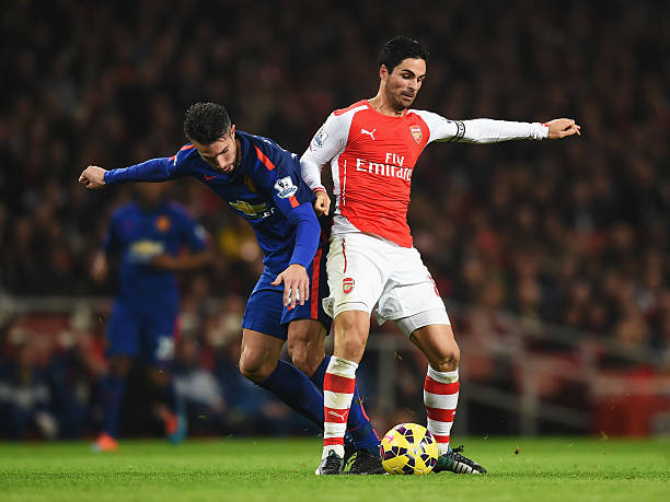 Van Persie picks his favourite to win the Premier League 2 LONDON, ENGLAND - NOVEMBER 22: Mikel Arteta of Arsenal is tackled by Robin van Persie of Manchester United during the Barclays Premier League match between Arsenal and Manchester United at Emirates Stadium on November 22, 2014 in London, England. (Photo by Michael Regan/Getty Images)