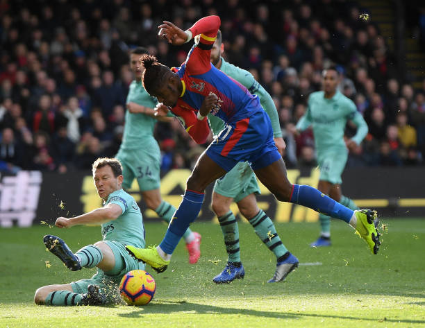LONDON, ENGLAND - OCTOBER 28: Wilfried Zaha of Crystal Palace has his shot blocked by Stephan Lichtsteiner of Arsenal during the Premier League mat...
