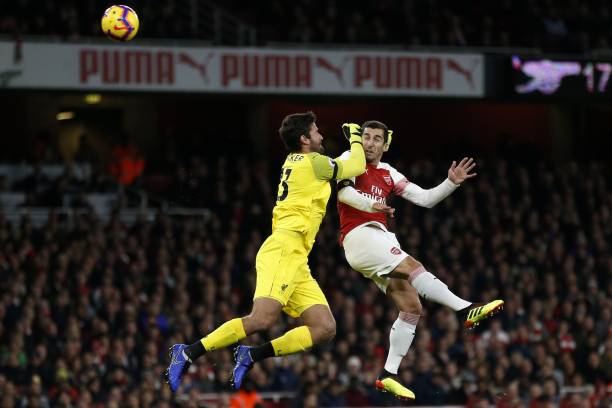 TOPSHOT - Arsenal's Armenian midfielder Henrikh Mkhitaryan (R) heads wide as Liverpool's Brazilian goalkeeper Alisson Becker comes out to challenge...