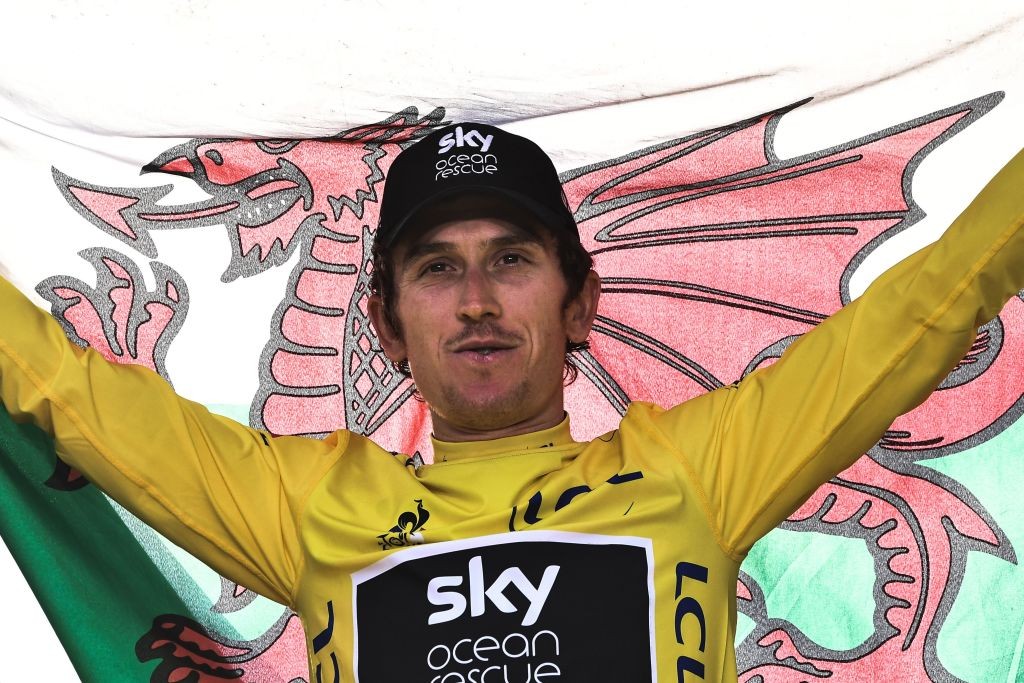 Tour de France 2018 winner Great Britain's Geraint Thomas holds a Welsh flag as he celebrates his overall leader yellow jersey on the podium after ...
