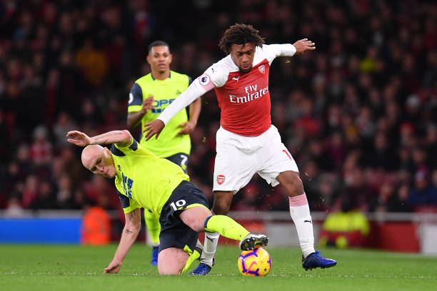 LONDON, ENGLAND - DECEMBER 08: Alex Iwobi of Arsenal is tackled by Aaron Mooy of Huddersfield Town during the Premier League match between Arsenal ...