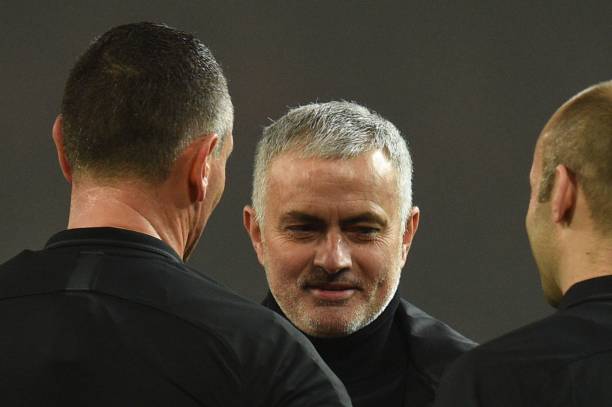 Manchester United's Portuguese manager Jose Mourinho (C) talks with the officials during the English Premier League football match between Manchest...