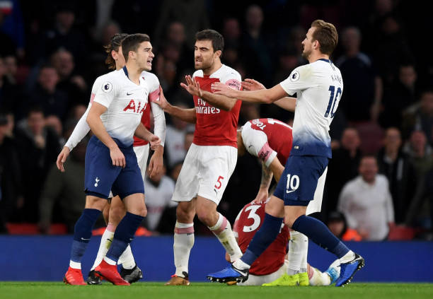 LONDON, ENGLAND - DECEMBER 02: Harry Winks of Tottenham Hotspur and Harry Kane of Tottenham Hotspur clash with Sokratis Papastathopoulos of Arsenal during the Premier League match between Arsenal FC and Tottenham Hotspur at Emirates Stadium on December 1, 2018 in London, United Kingdom. (Photo by Shaun Botterill/Getty Images)