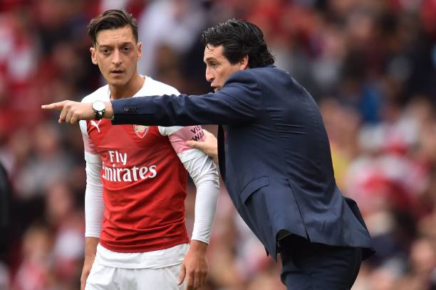 Arsenal's Spanish head coach Unai Emery gestures to Arsenal's German midfielder Mesut Ozil (L) on the touchline during the English Premier League f...