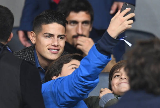 TOPSHOT - Colombian footballer James Rodriguez poses with fans as he takes his seat at the Santiago Bernabeu stadium in Madrid before thet start of...