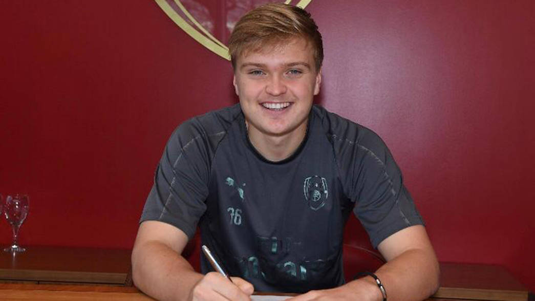 Matt Smith signing his first professional contract with Arsenal (Photo via Arsenal.com)