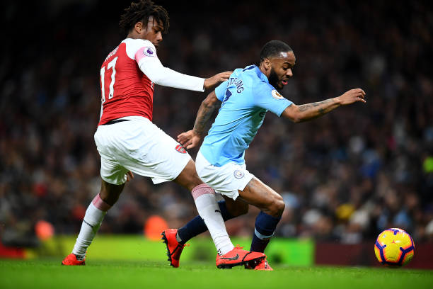 MANCHESTER, ENGLAND - FEBRUARY 03: Raheem Sterling of Manchester City is challenged by Alex Iwobi of Arsenal during the Premier League match betwee...