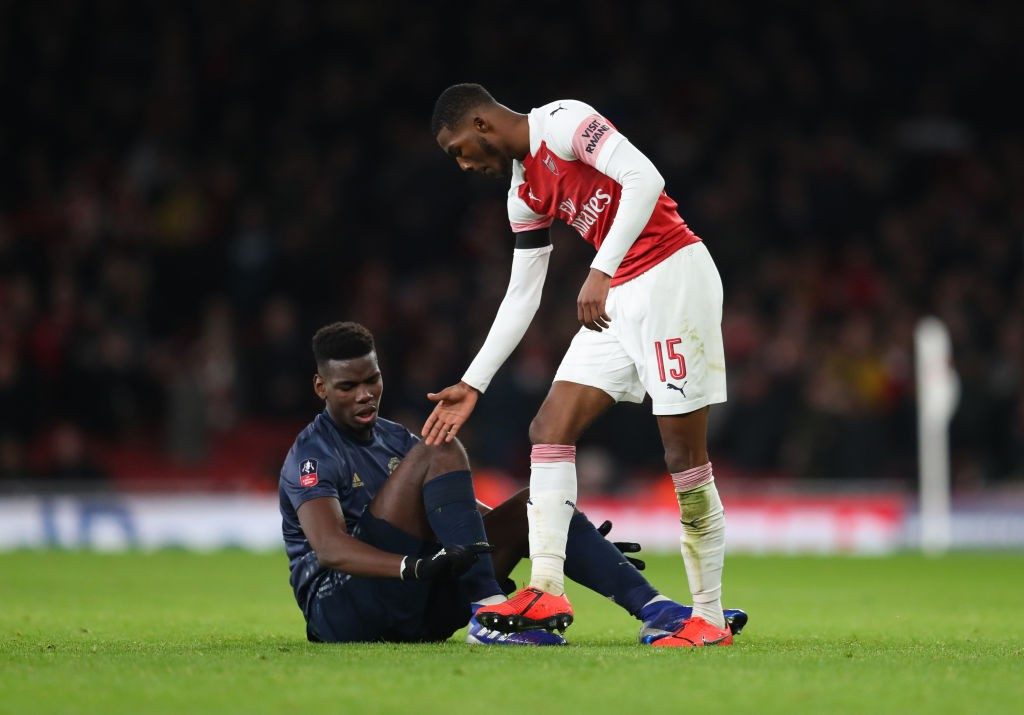 LONDON, ENGLAND - JANUARY 25: Ainsley Maitland-Niles of Arsenal offers his hand to Paul Pogba of Manchester United during the FA Cup Fourth Round match between Arsenal and Manchester United at Emirates Stadium on January 25, 2019 in London, United Kingdom. (Photo by Catherine Ivill/Getty Images)