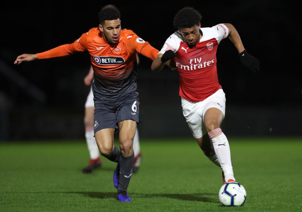 BOREHAMWOOD, ENGLAND - MARCH 04: Xavier Amaechi of Arsenal is challenged by Ben Cabango of Swansea City during the Premier League 2 match between A...