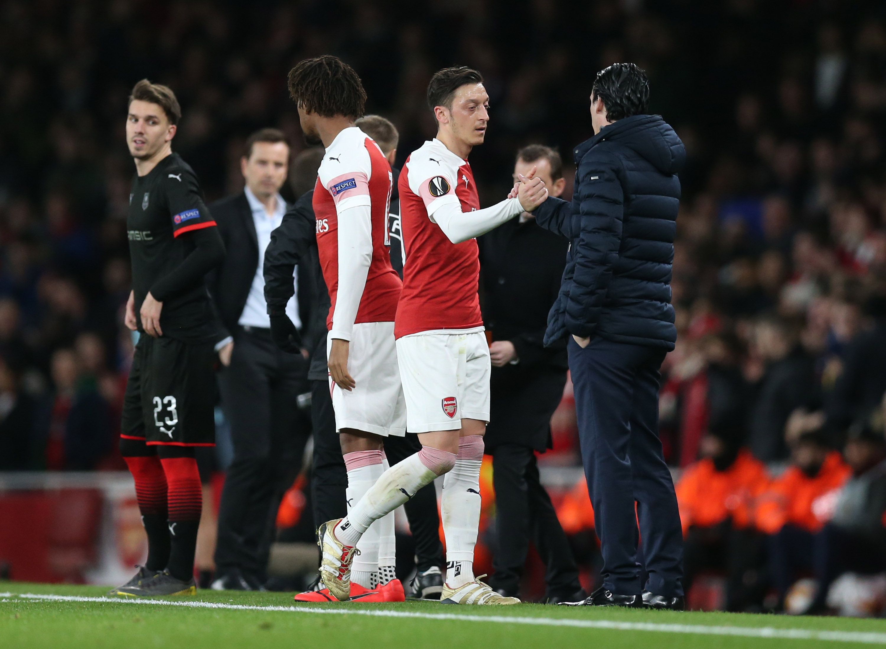 Mesut Ozil of Arsenal embraces Unai Emery, Manager of Arsenal as he is substituted during the UEFA Europa League Round of 16 Second Leg match betwe...