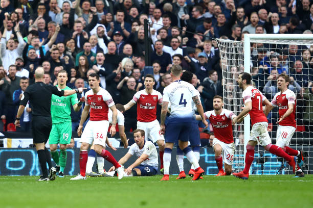 LONDON, ENGLAND - MARCH 02: Arsenal players confront referee Anthony Taylor after he awards Tottenham Hotspur a penalty that leads to their first goal during the Premier League match between Tottenham Hotspur and Arsenal FC at Wembley Stadium on March 02, 2019 in London, United Kingdom. (Photo by Julian Finney/Getty Images)