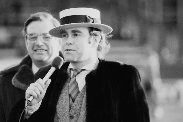 British singer-songwriter, pianist and composer Elton John talking before a West Ham United FC vs Arsenal FC match at Upton park, London, UK, 10th December 1983. (Photo by Sapiano/Daily Express/Hulton Archive/Getty Images)