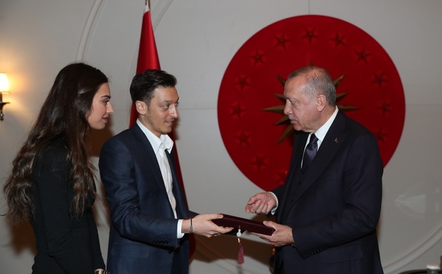 Mesut Özil, center, and his fiancée Amine Gülşe, left, give a wedding invitation to President Recep Tayyip Erdoğan at the Atatürk Airport in Istanb...