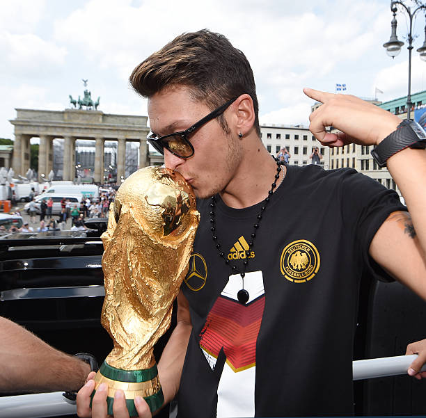 BERLIN, GERMANY - JULY 15: Mesut Oezil celebrates on the open top bus at the German team victory ceremony on July 15, 2014 in Berlin, Germany. Germ...