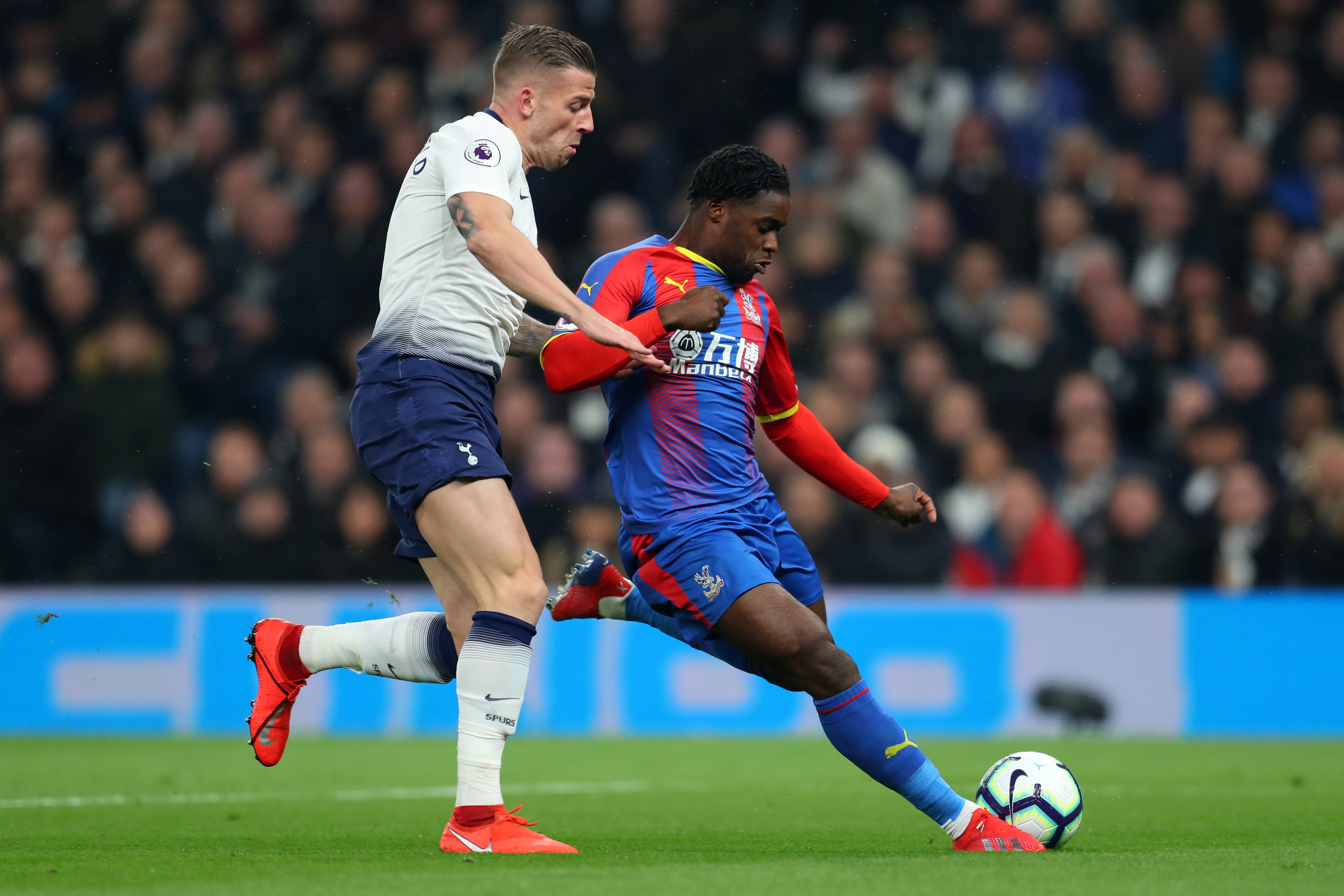 Jeffrey Schlupp of Crystal Palace (R) is challenged by Toby Alderweireld of Tottenham Hotspur during the Premier League match between Tottenham Hot...