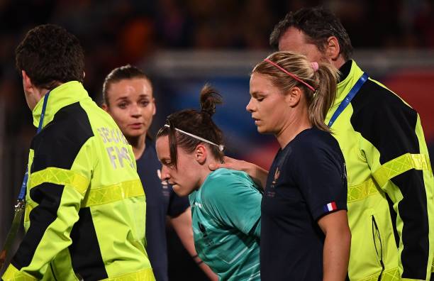 France's goalkeeper Pauline Peyraud-Magnin (C) is stretched out due to an injury during the FIFA international friendly football match between Fran...