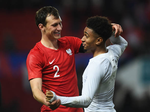 BRISTOL, ENGLAND - MARCH 21: Krystian Bielik of Poland and Reiss Nelson of England share a joke after the U21 International Friendly match between ...