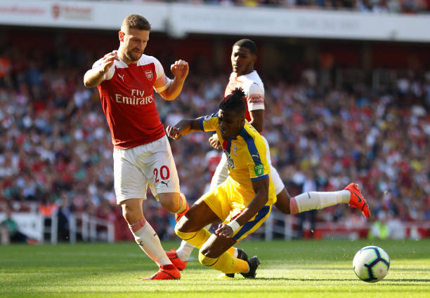 Wilfried Zaha eyes free move, Arsenal linked but shouldn't be 2 LONDON, ENGLAND - APRIL 21: Wilfried Zaha of Crystal Palace is challenged by Shkodran Mustafi of Arsenal during the Premier League match between Arsenal FC and Crystal Palace at Emirates Stadium on April 21, 2019 in London, United Kingdom. (Photo by Warren Little/Getty Images)