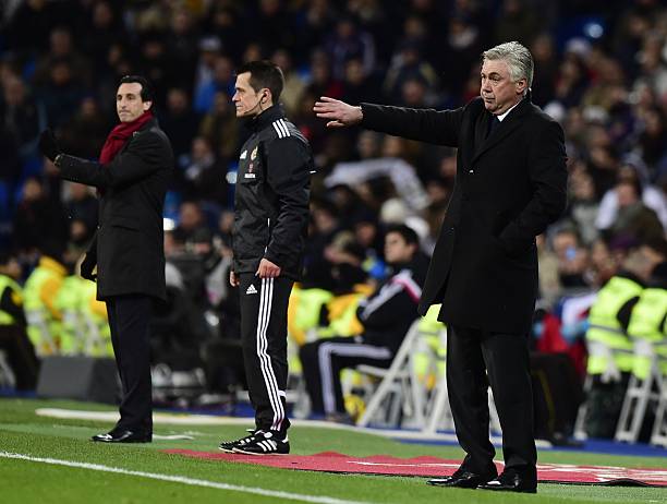 Real Madrid's Italian head coach Carlo Ancelotti (R) and Sevilla's coach Unai Emery (L) gesture during the Spanish league football match Real Madri...