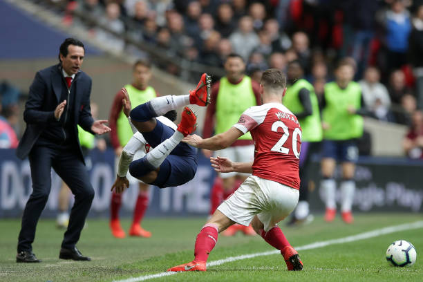 Arsenal's Spanish head coach Unai Emery (L) looks on as Tottenham Hotspur's English defender Danny Rose (2nd L) is knocked off the ball by Arsenal'...