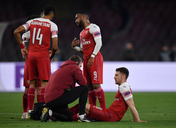 NAPLES, ITALY - APRIL 18: Aaron Ramsey of Arsenal recieves treatment for an injury during the UEFA Europa League Quarter Final Second Leg match between S.S.C. Napoli and Arsenal at Stadio San Paolo on April 18, 2019 in Naples, Italy. (Photo by Stuart Franklin/Getty Images)