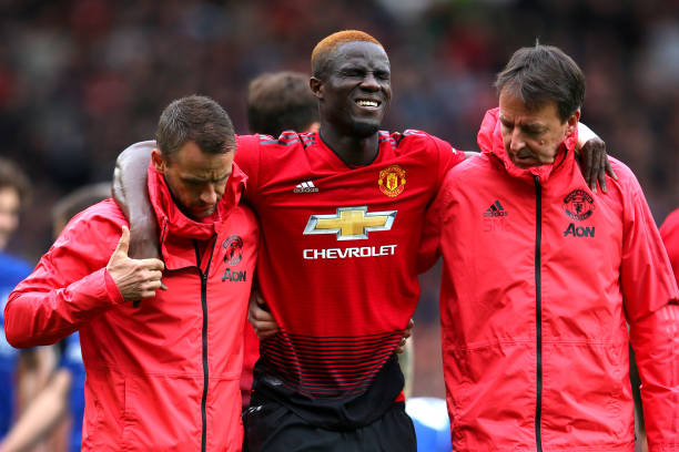MANCHESTER, ENGLAND - APRIL 28: An injured Eric Bailly of Manchester United is given assistance during the Premier League match between Manchester ...