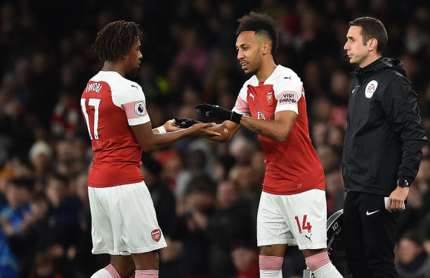 Arsenal's Nigerian striker Alex Iwobi (L) leaves the pitch after being substituted off for Arsenal's Gabonese striker Pierre-Emerick Aubameyang dur...