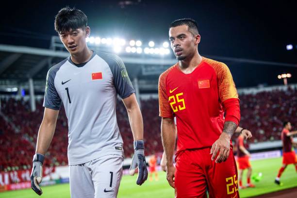 China's Nico Yennaris (R), known as Li Ke in Chinese, walks off with goalkeeper Yan Junling after the team's football friendly match against the Ph...