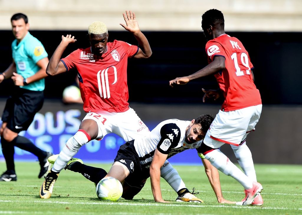 Angers' French midfielder Thomas Mangani (C) fights for the ball with Lille's Malian midfielder Yves Bissouma (L) and Lille's Ivorian forward Nicol...