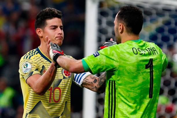 Colombia's James Rodriguez (L) greets his teammate goalkeeper David Ospina after scoring his penalty during the penalty shoot-out against Chile aft...