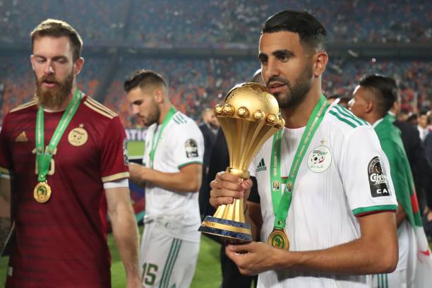 Algeria's forward Riyad Mahrez (R) celebrates with the trophy during the 2019 Africa Cup of Nations (CAN) Final football match between Senegal and Algeria at the Cairo International Stadium in Cairo on July 19, 2019. (Photo by Khaled DESOUKI / AFP)        