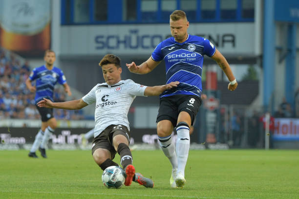 BIELEFELD, GERMANY - JULY 29: Ryo Miyaichi (L) of St. Pauli and Florian Hartherz of Bielefeld fight for the ball during the Second Bundesliga match between DSC Arminia Bielefeld and FC St. Pauli at Schueco Arena on July 29, 2019 in Bielefeld, Germany. (Photo by Thomas F. Starke/Bongarts/Getty Images)