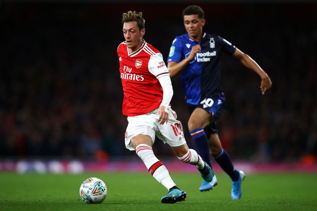 LONDON, ENGLAND - SEPTEMBER 24: Mesut Ozil of Arsenal gets past the tackle from Brennan Johnson of Nottingham Forest during the Carabao Cup Third R...