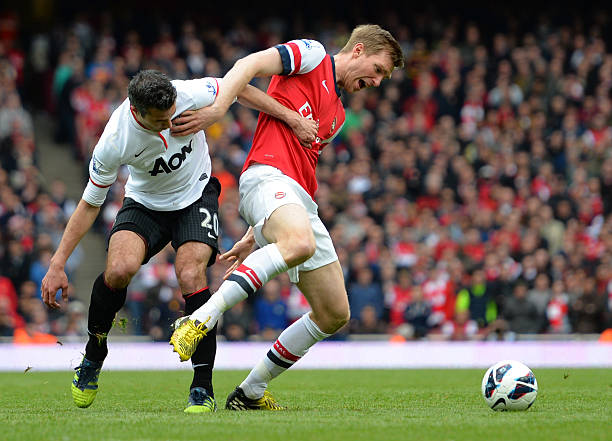 Robin van Persie gets annoyed at Per Mertesacker 3 LONDON, ENGLAND - APRIL 28: Per Mertesacker of Arsenal and Robin van Persie of Manchester United battle for the ball during the Barclays Premier League match between Arsenal and Manchester United at Emirates Stadium on April 28, 2013 in London, England. (Photo by Shaun Botterill/Getty Images)