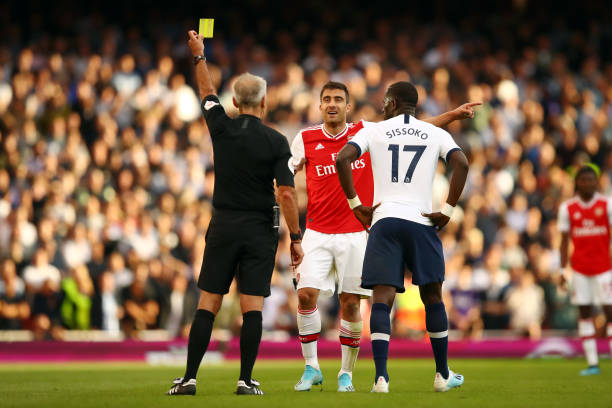 LONDON, ENGLAND - SEPTEMBER 01: Sokratis Papastathopoulos of Arsenal is shown a yellow card by referee Martin Atkinson during the Premier League ma...