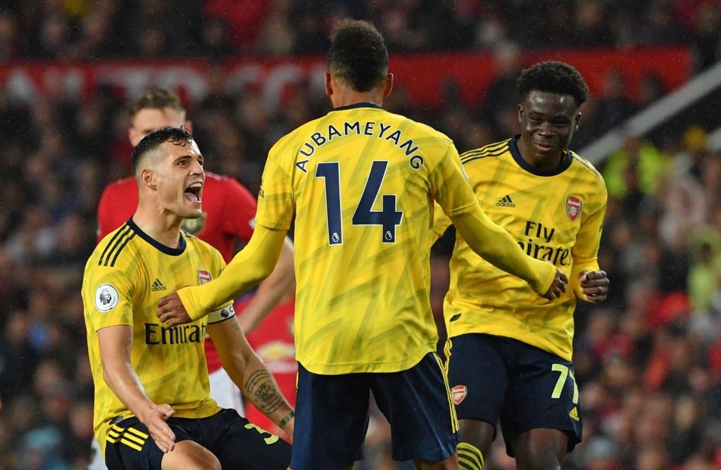 Player ratings vs Manchester United: Saka stars as Arsenal come from behind to draw 2 Arsenal's Gabonese striker Pierre-Emerick Aubameyang (C) celebrates with Arsenal's Swiss midfielder Granit Xhaka (L) and Arsenal's English striker Bukayo Saka (R) after scoring their first goal, decision of off-side overturned by VAR (Video Assistant referee) during the English Premier League football match between Manchester United and Arsenal at Old Trafford in Manchester, north west England, on September 30, 2019. (PAUL ELLIS / AFP / Getty Images)