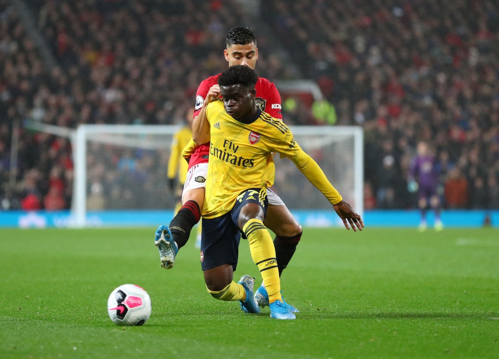 MANCHESTER, ENGLAND - SEPTEMBER 30: Bukayo Saka of Arsenal and Andreas Pereira of Manchester United during the Premier League match between Manches...
