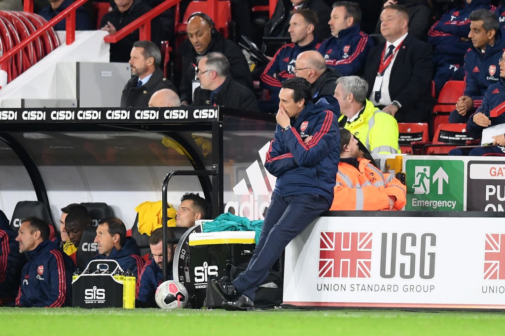 SHEFFIELD, ENGLAND - OCTOBER 21: Unai Emery, Manager of Arsenal sits on an advertising board on the sideline during the Premier League match betwee...