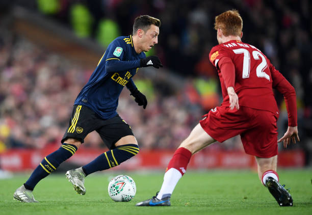 LIVERPOOL, ENGLAND - OCTOBER 30: Mesut Ozil of Arsenal is challenged by Sepp Van Den Berg of Liverpool during the Carabao Cup Round of 16 match between Liverpool and Arsenal at Anfield on October 30, 2019 in Liverpool, England. (Photo by Laurence Griffiths/Getty Images)