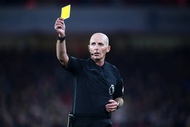 SHEFFIELD, ENGLAND - OCTOBER 21: Match Referee Mike Dean shows the Yellow card during the Premier League match between Sheffield United and Arsenal...