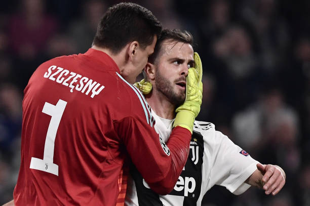 Juventus' Polish goalkeeper Wojciech Szczesny (L) congratulates Juventus' Bosnian midfielder Miralem Pjanic after he saved a ball in the penalty area during the UEFA Champions League quarter-final second leg football match Juventus vs Ajax Amsterdam on April 16, 2019 at the Juventus stadium in Turin. (Photo by Marco Bertorello / AFP) 