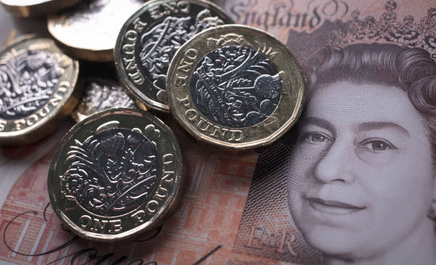 BATH, ENGLAND - OCTOBER 13: In this photo illustration, £1 coins are seen with the new £10 note on October 13, 2017 in Bath, England. Currency expe...