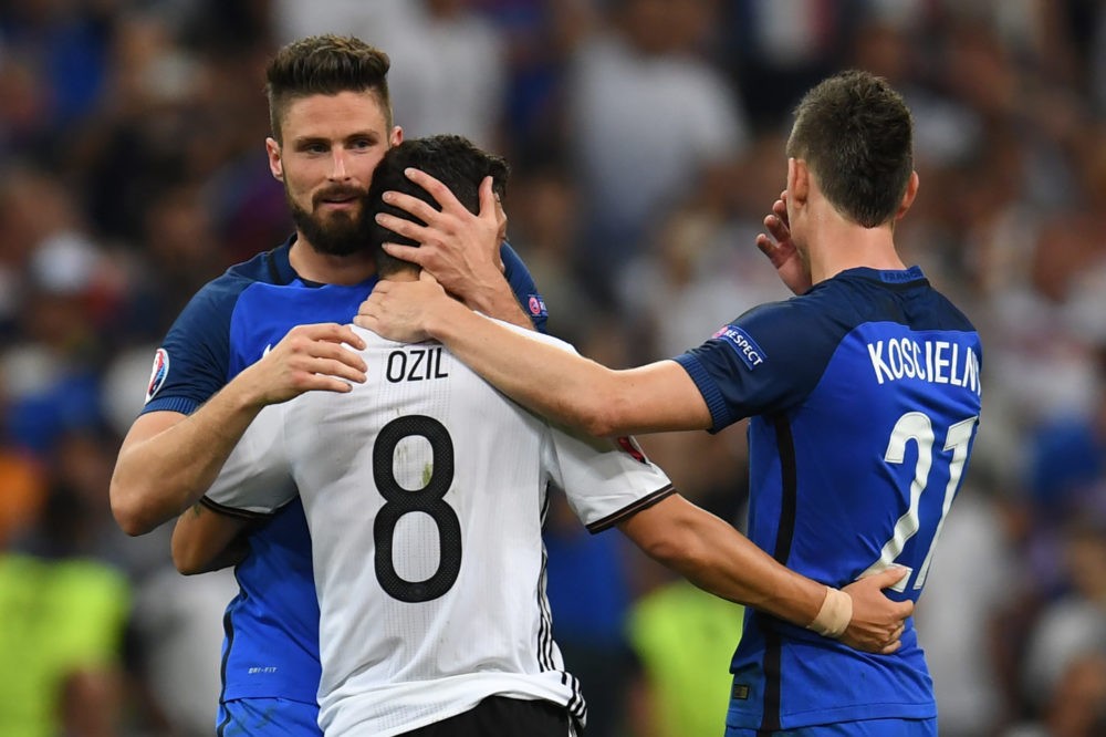 TOPSHOT - France's forward Olivier Giroud (L) and France's defender Laurent Koscielny (R) consol Germany's midfielder Mesut Oezil after France beat Germany 2-0 in the Euro 2016 semi-final football match between Germany and France at the Stade Velodrome in Marseille on July 7, 2016. France will face Portugal in the finals on July 10, 2016. / AFP / PATRIK STOLLARZ