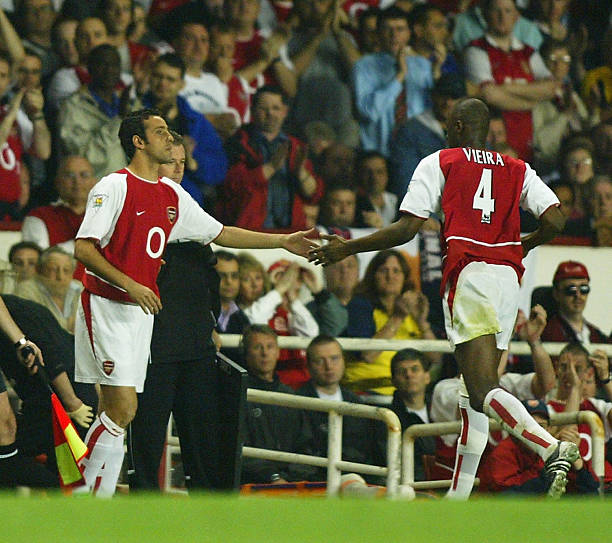 LONDON - APRIL 16:  Patrick Vieira of Arsenal shakes hands with Edu as he is substituted due to a recurring knee injury during the FA Barclaycard Premiership match between Arsenal and Manchester United at Highbury on April 16, 2003 in London. (Photo By Ben Radford/Getty Images)