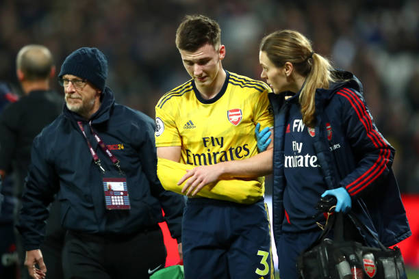 LONDON, ENGLAND - DECEMBER 09: Kieran Tierney of Arsenal leaves the pitch following an injury during the Premier League match between West Ham Unit...