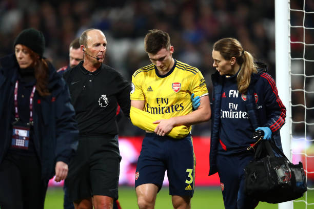 2 big injury doubts for Arsenal ahead of Chelsea match 2 LONDON, ENGLAND - DECEMBER 09: Referee Mike Dean helps Kieran Tierney of Arsenal leave the pitch following an injury during the Premier League match between West Ham United and Arsenal FC at London Stadium on December 09, 2019 in London, United Kingdom. (Photo by Julian Finney/Getty Images)